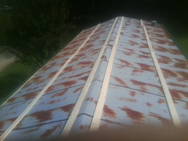 Rusted metal roof panels with new wood purlins before replacement — Storm Damage Roof Repair in Winterville by Roofing Brothers