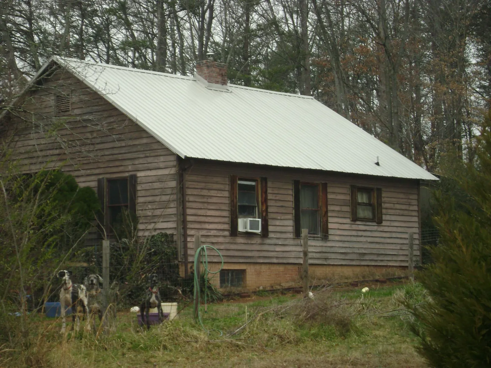 White metal roof on an old wood sided farmhouse, from a Metal Roof Installation job in Winterville